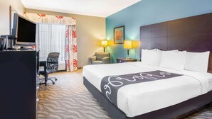 A hotel room with a large bed, a desk with a computer, a chair, and a TV. - La Quinta Inn & Suites by Wyndham Glen Rose (Glen Rose)