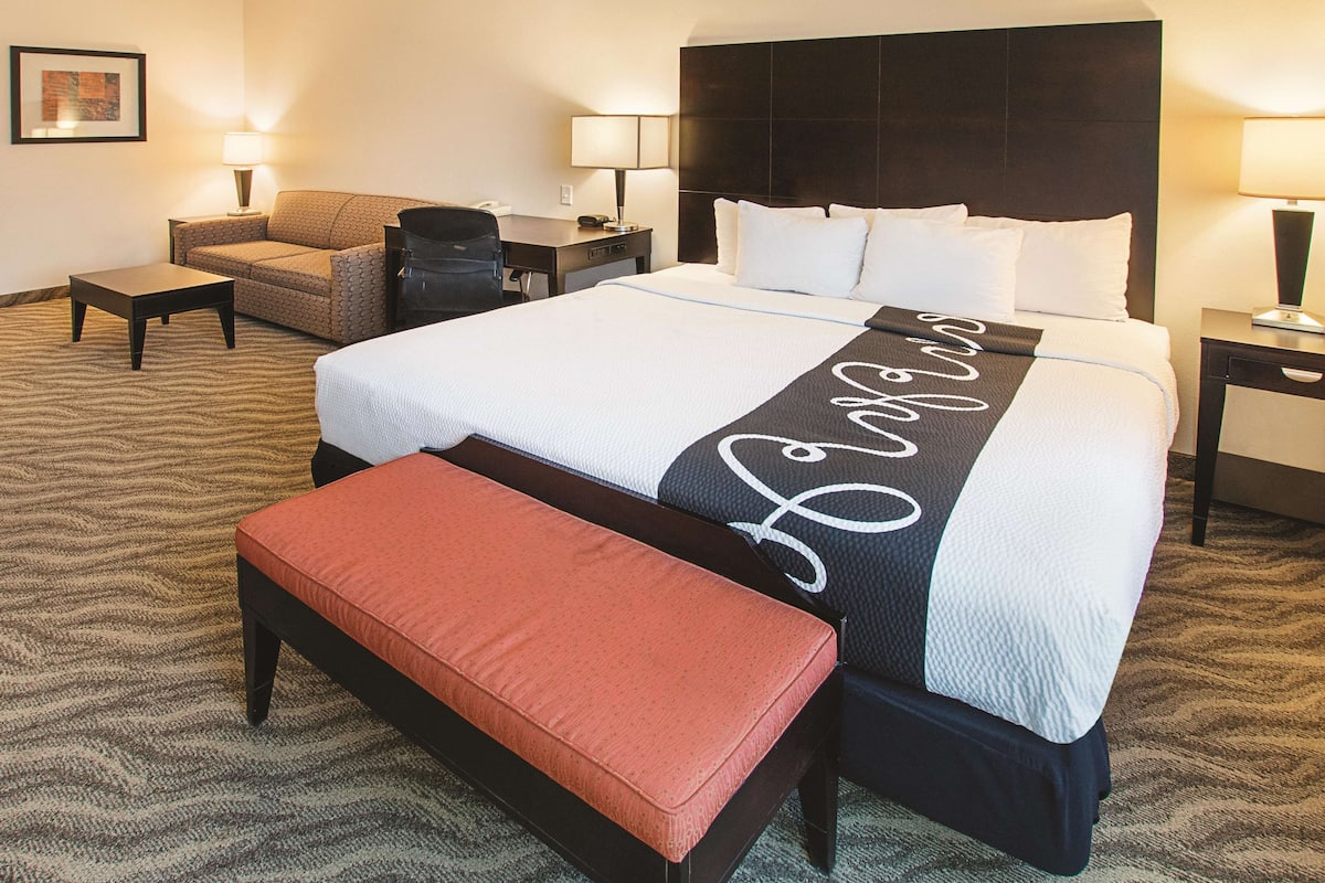 Une chambre d’hôtel avec un grand lit, un canapé, un bureau et une chaise.