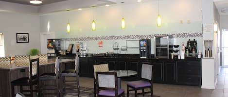 A modern kitchen with a central island, bar seating, and pendant lighting.
