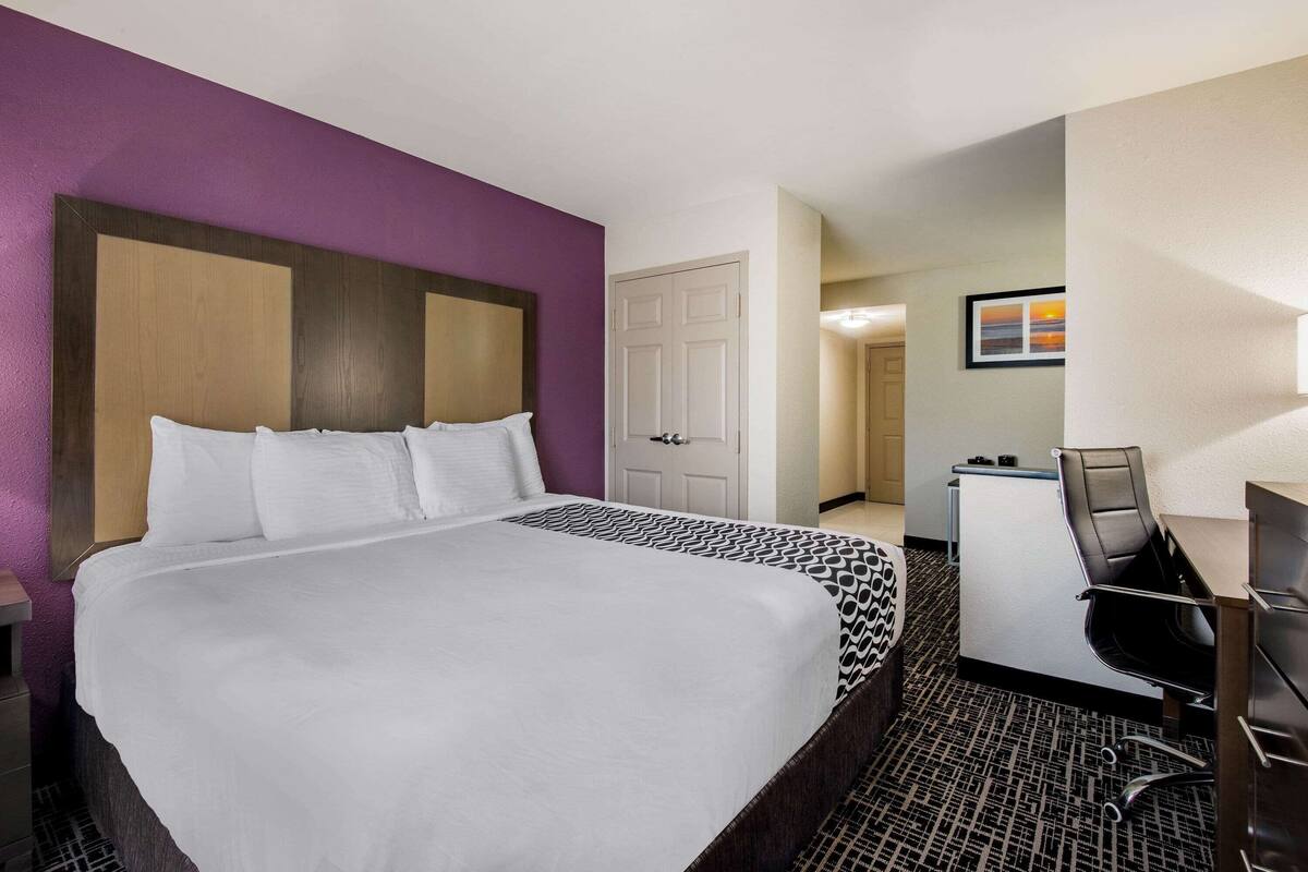 Une chambre d’hôtel avec un grand lit, un bureau et une chaise.