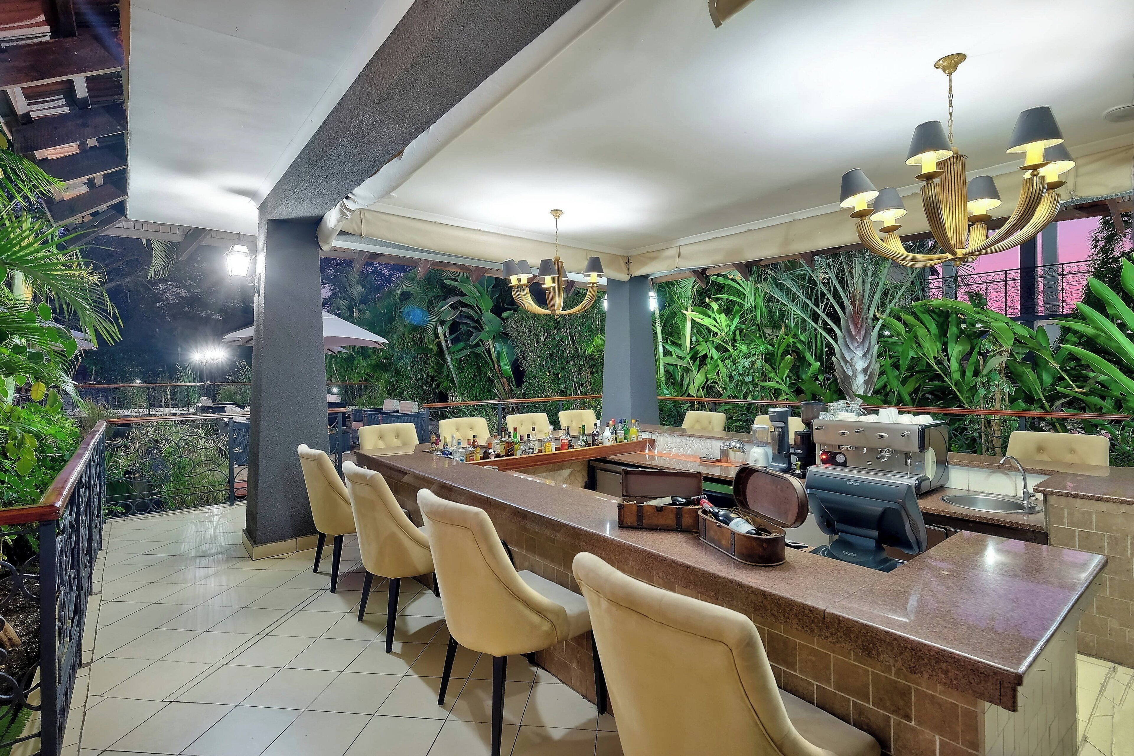 A bar area with a long counter, multiple chairs, and a grill station.