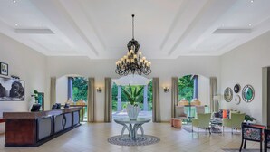 A spacious lobby with a reception desk, a chandelier, and seating area. - Protea Hotel by Marriott Livingstone (Livingstone)