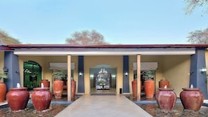 A covered walkway with large vases and a chandelier in the center. - Protea Hotel by Marriott Livingstone (Livingstone)