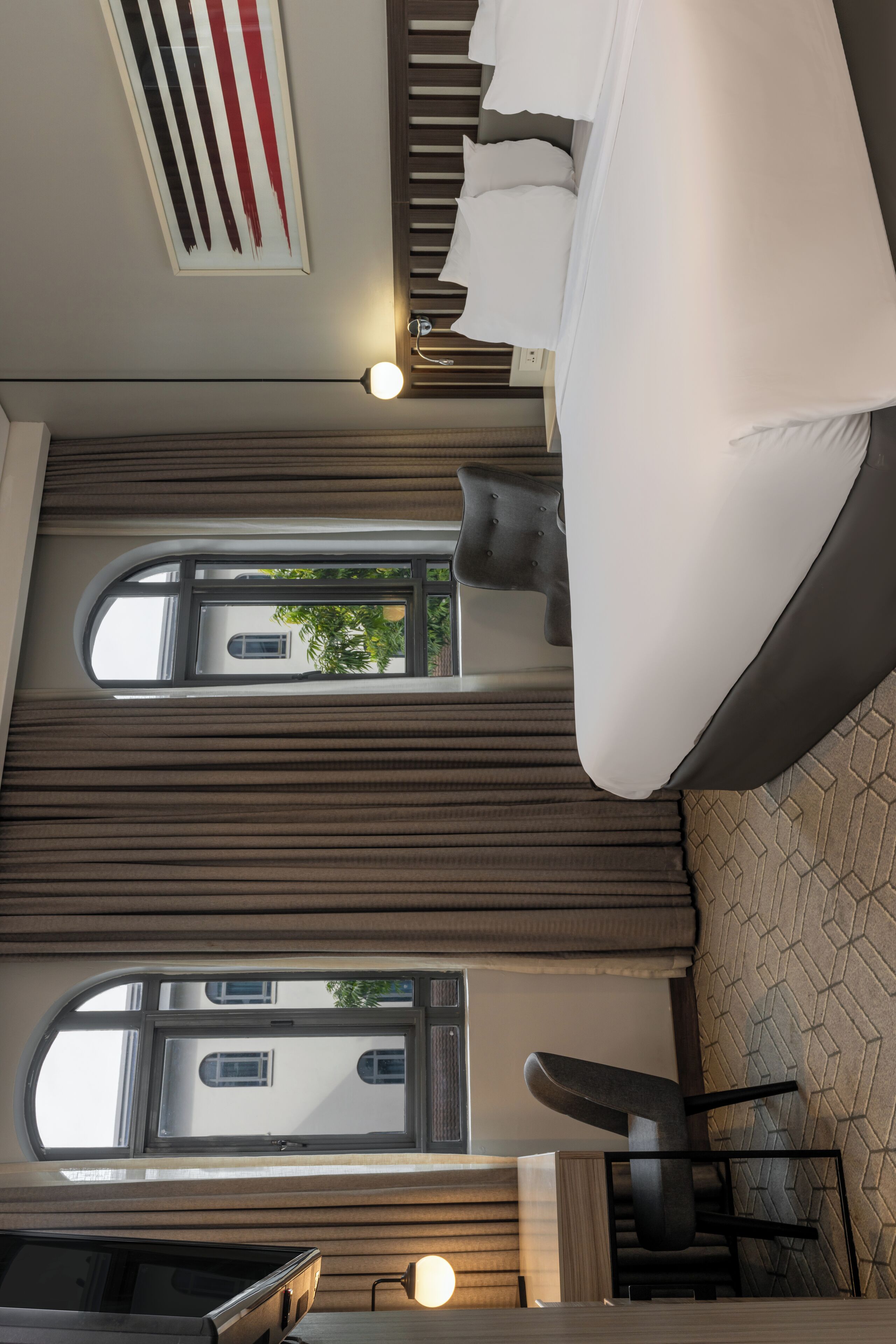 A modern interior with a sofa, a table, and a view of a building through a window.