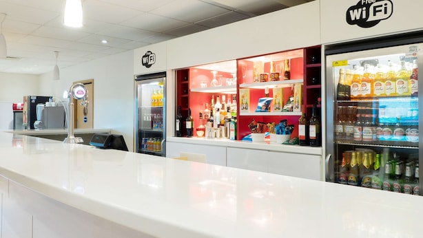 A clean, modern bar area with a white countertop, a minibar, and a free Wi-Fi sign. - Travelodge Middlesbrough (Middlesbrough)
