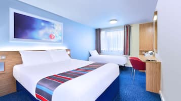 A hotel room with a large bed, a desk, and a chair.