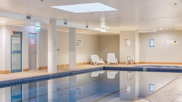 Zona de piscina con sillones de descanso, salida de incendios y señalización de seguridad.
