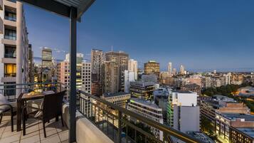 A balcony with a view of a cityscape at dusk.