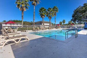 A swimming pool with lounge chairs and palm trees. -  Studio 6 Extended Stay - Kissimmee, FL - Orlando (Kissimmee)