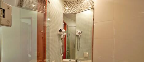 Un baño con lavamanos, espejo y secador de pelo.