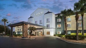A Fairfield by Marriott hotel with a covered entrance, palm trees, and a multi-story building.