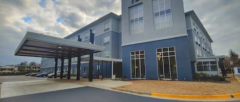 A Radisson hotel with a covered entrance, multiple windows, and a parking area.