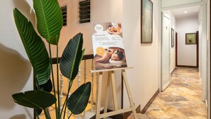 A hallway with a spa sign, a potted plant, and a poster. - Hong Ngoc Dynastie Boutique Hotel & Spa (Hanoi)