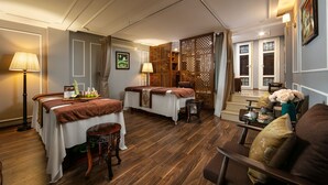 A room with two beds, a sitting area with a sofa and a table, and a decorative partition. - Hong Ngoc Dynastie Boutique Hotel & Spa (Hanoi)