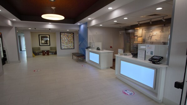 A reception area with a counter, seating, and a large painting on the wall. - Holiday Inn Express & Suites Somerset Central by IHG (Somerset)
