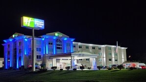 A Holiday Inn Express & Suites building at night with illuminated signage and a well-maintained lawn. - Holiday Inn Express & Suites Somerset Central by IHG (Somerset)