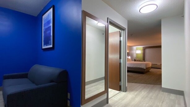 A hotel room with a blue accent wall, a bed, a desk, and a chair. - Holiday Inn Express & Suites Somerset Central by IHG (Somerset)
