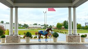A covered area with a horse statue, potted plants, and a flag. - Holiday Inn Express & Suites Somerset Central by IHG (Somerset)