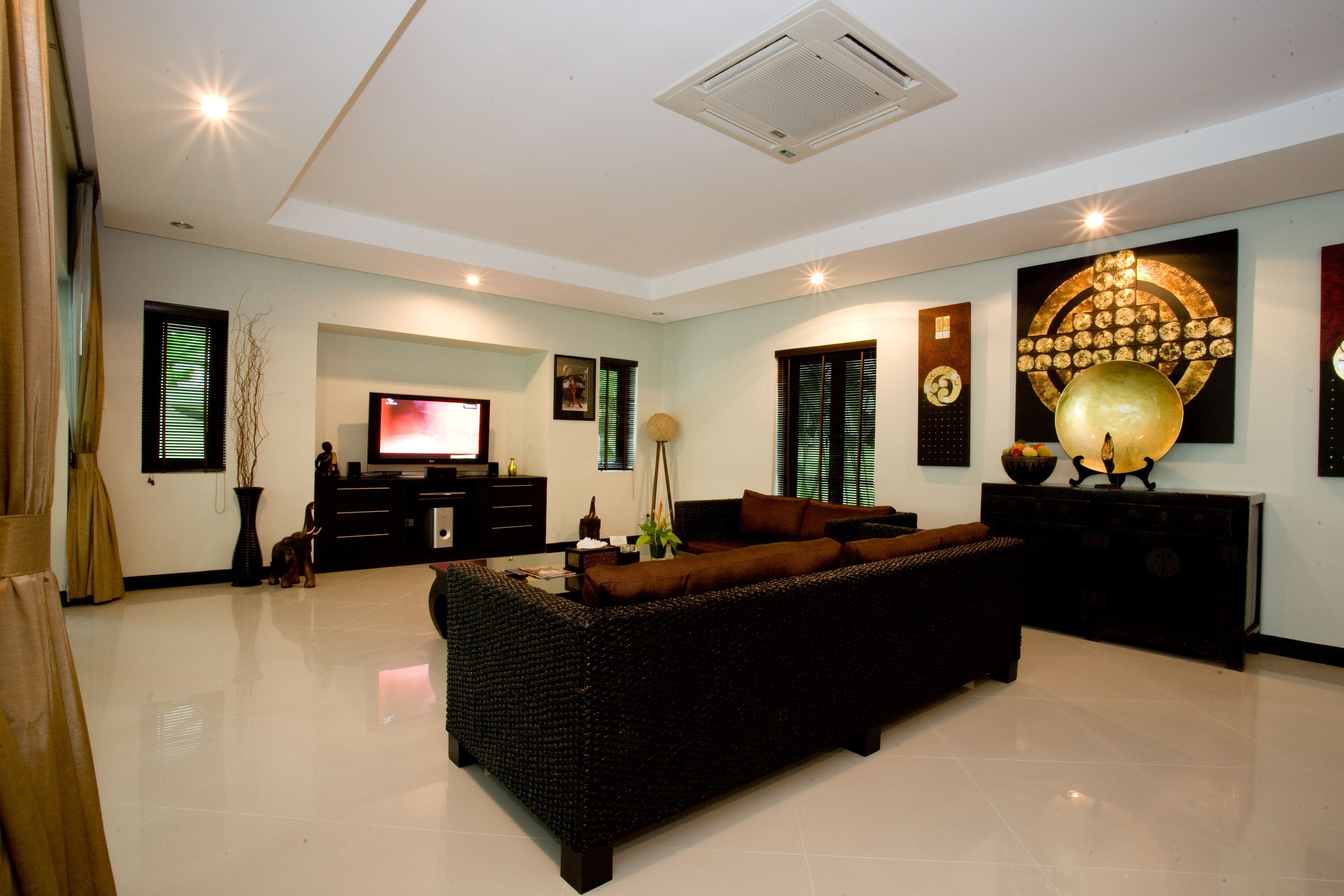 A modern living room with a large flat-screen TV, a sofa, a decorative globe, and a wall-mounted clock.