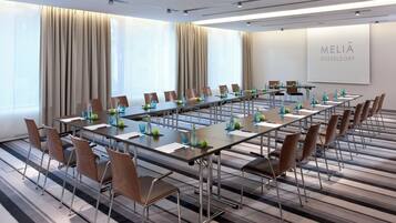 A conference room with long tables, chairs, and water bottles.