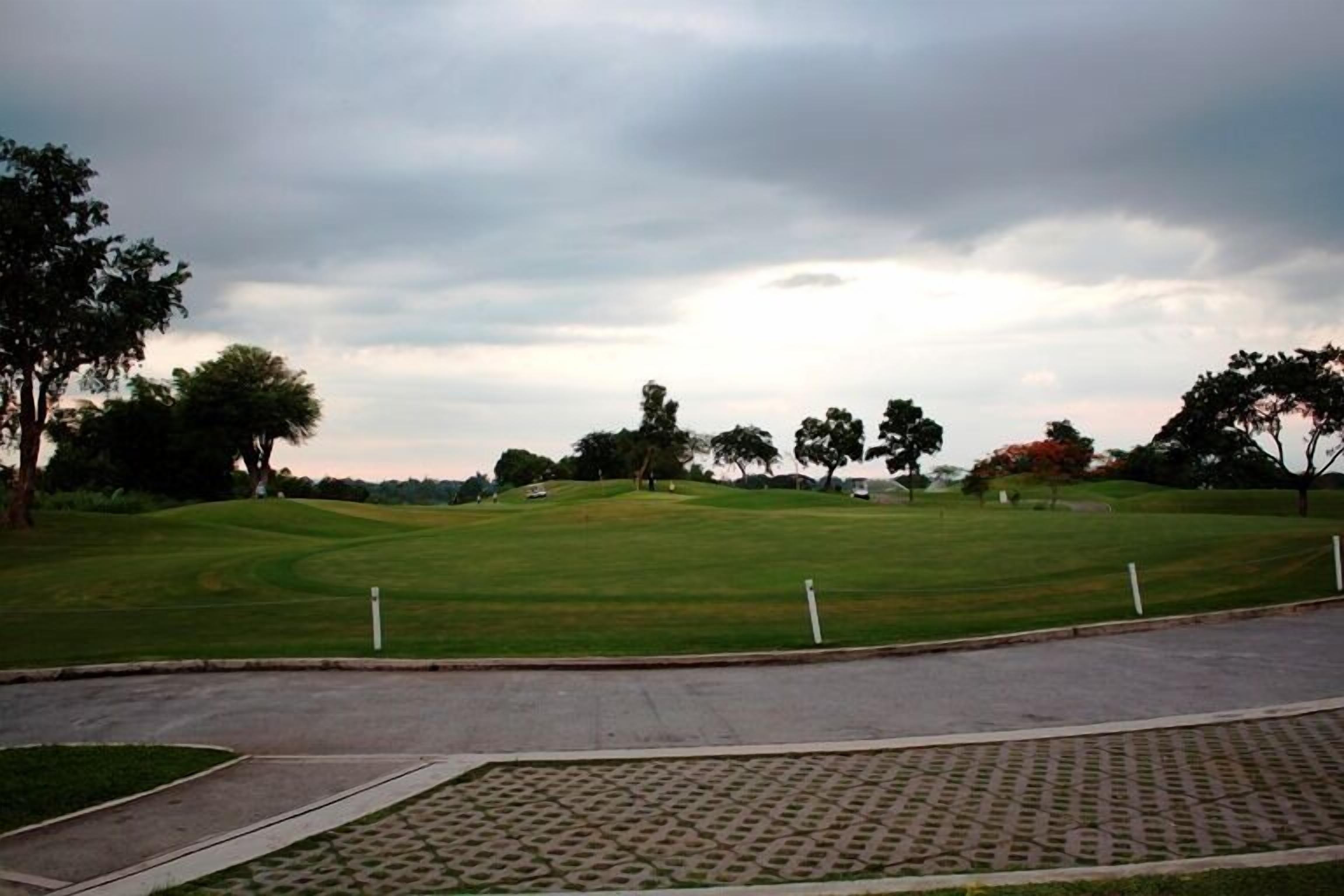 A golf course with a paved walkway and a grassy area.