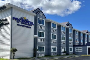 A Microtel by Wyndham Eagle Ridge hotel with a modern design, featuring multiple windows and a flat roof. - Microtel by Wyndham Eagle Ridge (General Trias)