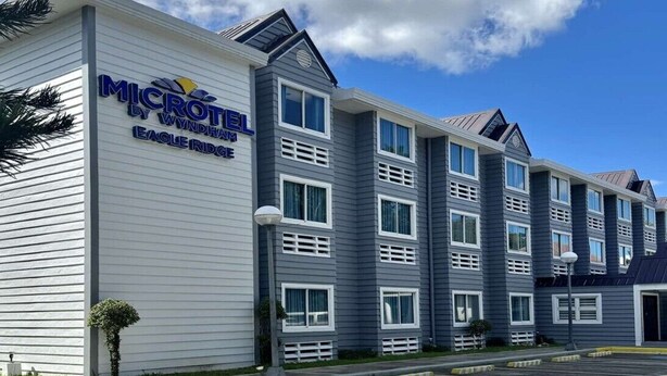 A Microtel by Wyndham Eagle Ridge hotel with a modern design, featuring multiple floors and a prominent signage. - Microtel by Wyndham Eagle Ridge (General Trias)