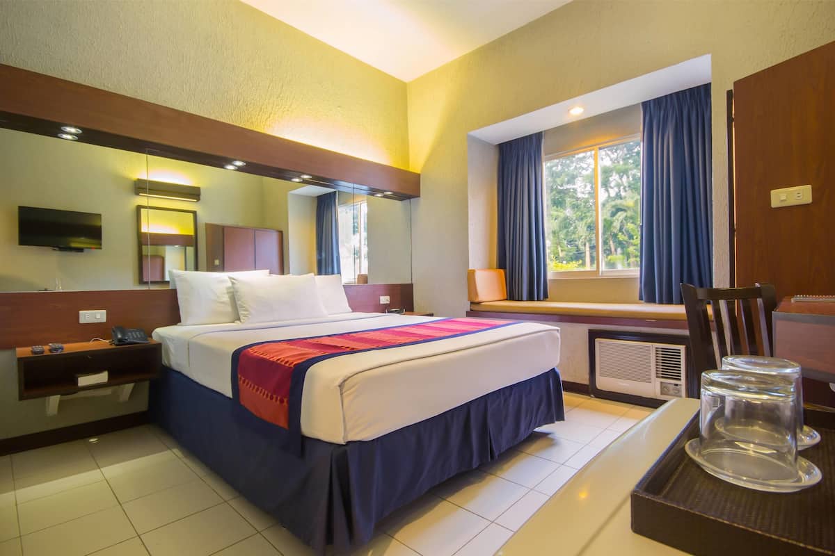 Relax in comfort with a large bed, flat-screen TV, and a convenient workspace near the window.