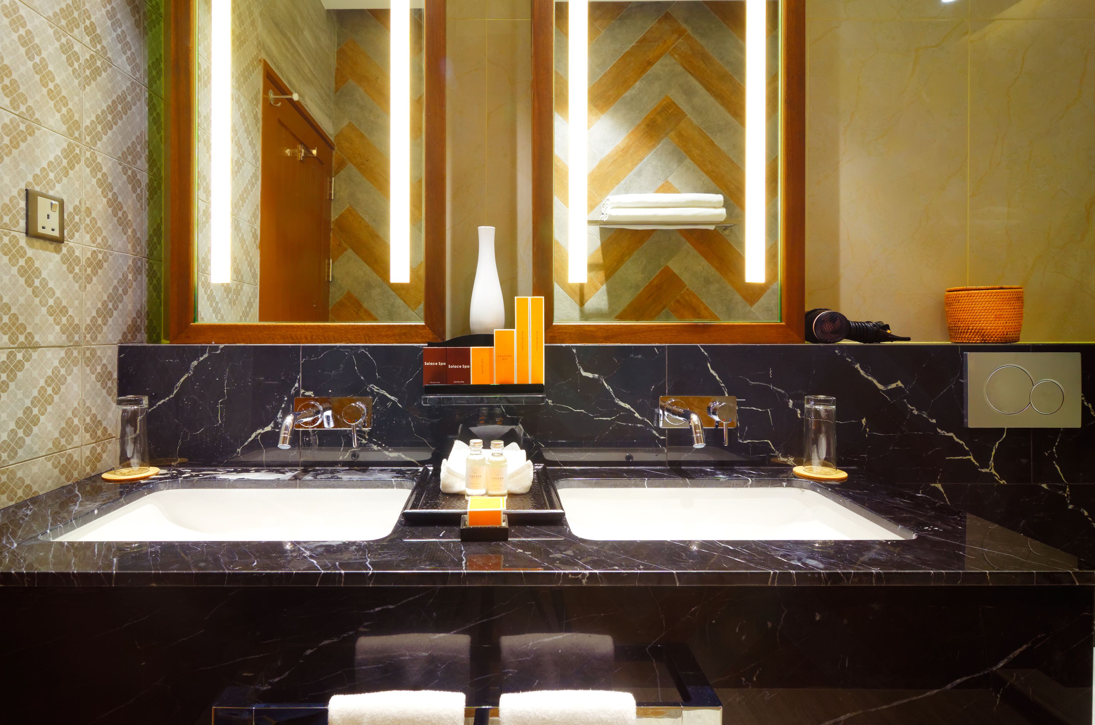 A bathroom with two sinks, a mirror, and a towel rack.