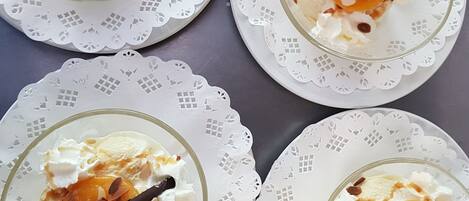 Four glass dessert bowls on white doilies.