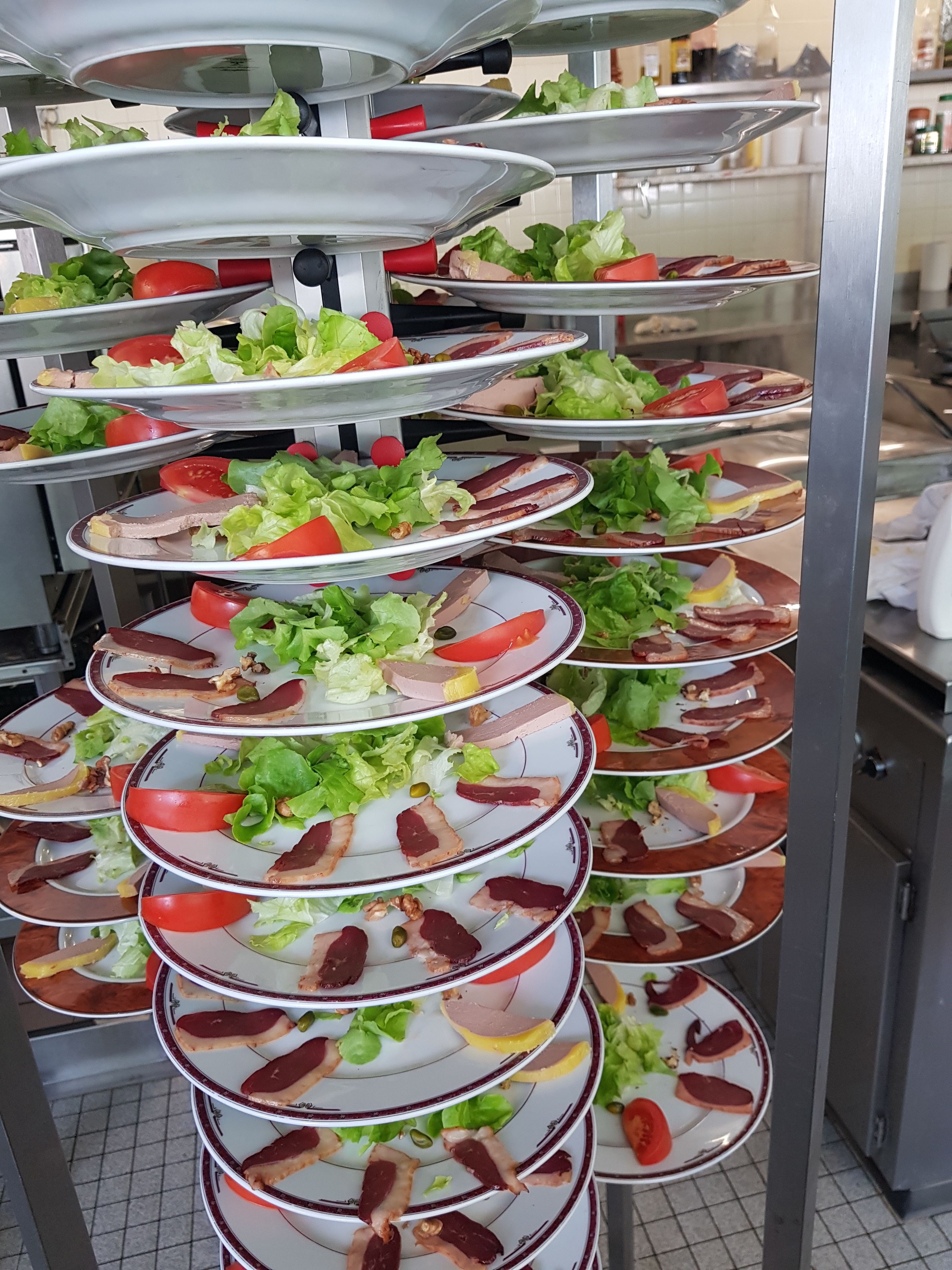 A multi-tiered serving station with various food items.