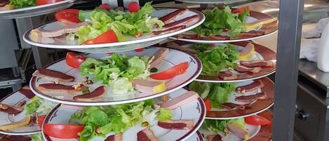 A multi-tiered serving station with various food items.