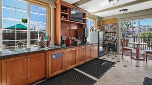 A spacious kitchen with wooden cabinets, a built-in TV, and a large window offering a view of the outside. - Motel Mediteran Escondido (Escondido)