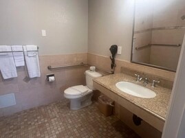 Un baño pequeño con inodoro, lavamanos y secamanos.