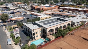 A motel with a swimming pool, multiple parking spaces, and a fenced construction area. - Motel Mediteran Escondido (Escondido)