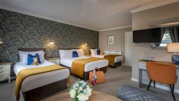 Habitación de hotel con dos camas, un escritorio, una silla, un televisor y una pared con diseño de piedra.