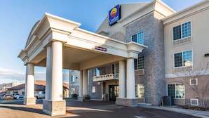 Un Comfort Inn con entrada cubierta, fachada de ladrillo y cielo despejado.