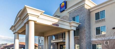 A Comfort Inn with a covered entrance, a brick facade, and a clear sky.