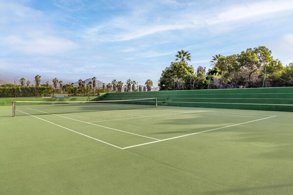 A tennis court with a net, surrounded by trees and a clear sky. - Royal Tenerife Country Club (San Miguel de Abona)