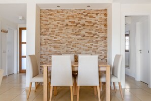 Ein Essbereich mit Holzpaneelen, vier Stühlen und einem Tisch.