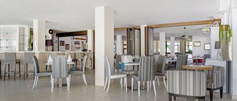 Un comedor amplio con muebles modernos, una zona de bar y vistas a la cocina.