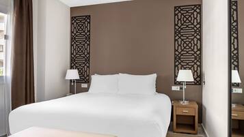A hotel room with a large bed, two bedside tables with lamps, a bench, and decorative wall panels.