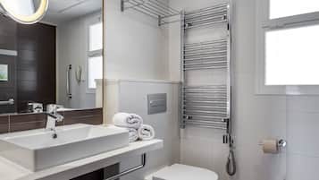 A modern bathroom with a white sink, a toilet, a towel rack, and a mirror.