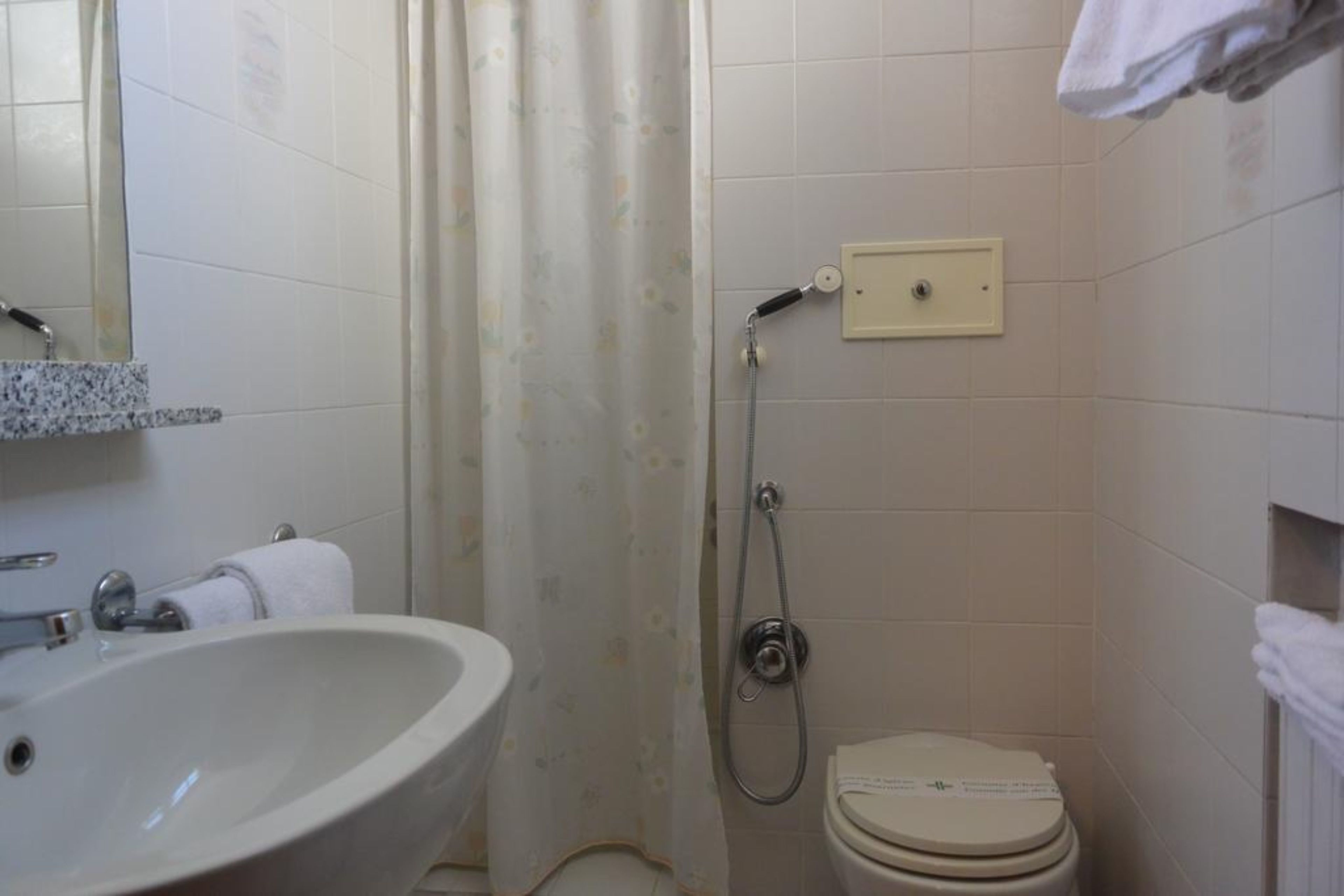 Ein Badezimmer mit Waschbecken, Toilette, Dusche und Spiegel.