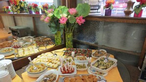Un bufé con diversos platos y un jarrón de flores.