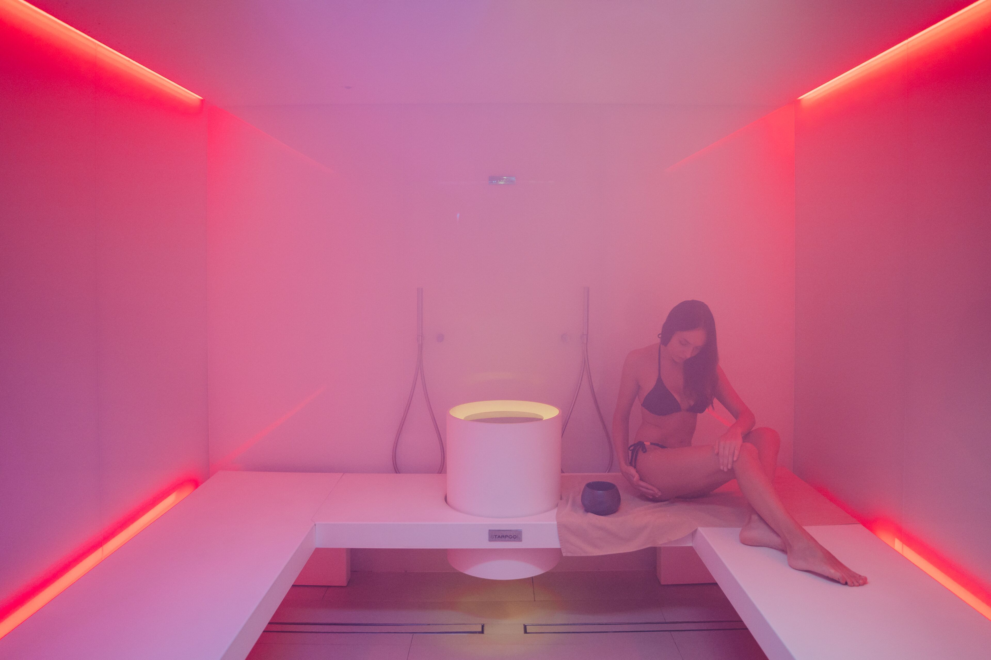 Une pièce avec un lit, une lampe et une petite table.