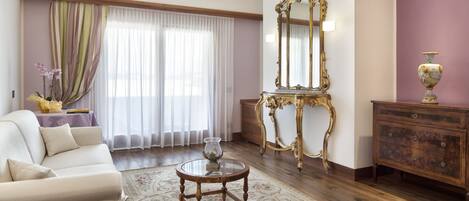 A living room with a sofa, a round coffee table, a mirror, and a cabinet.