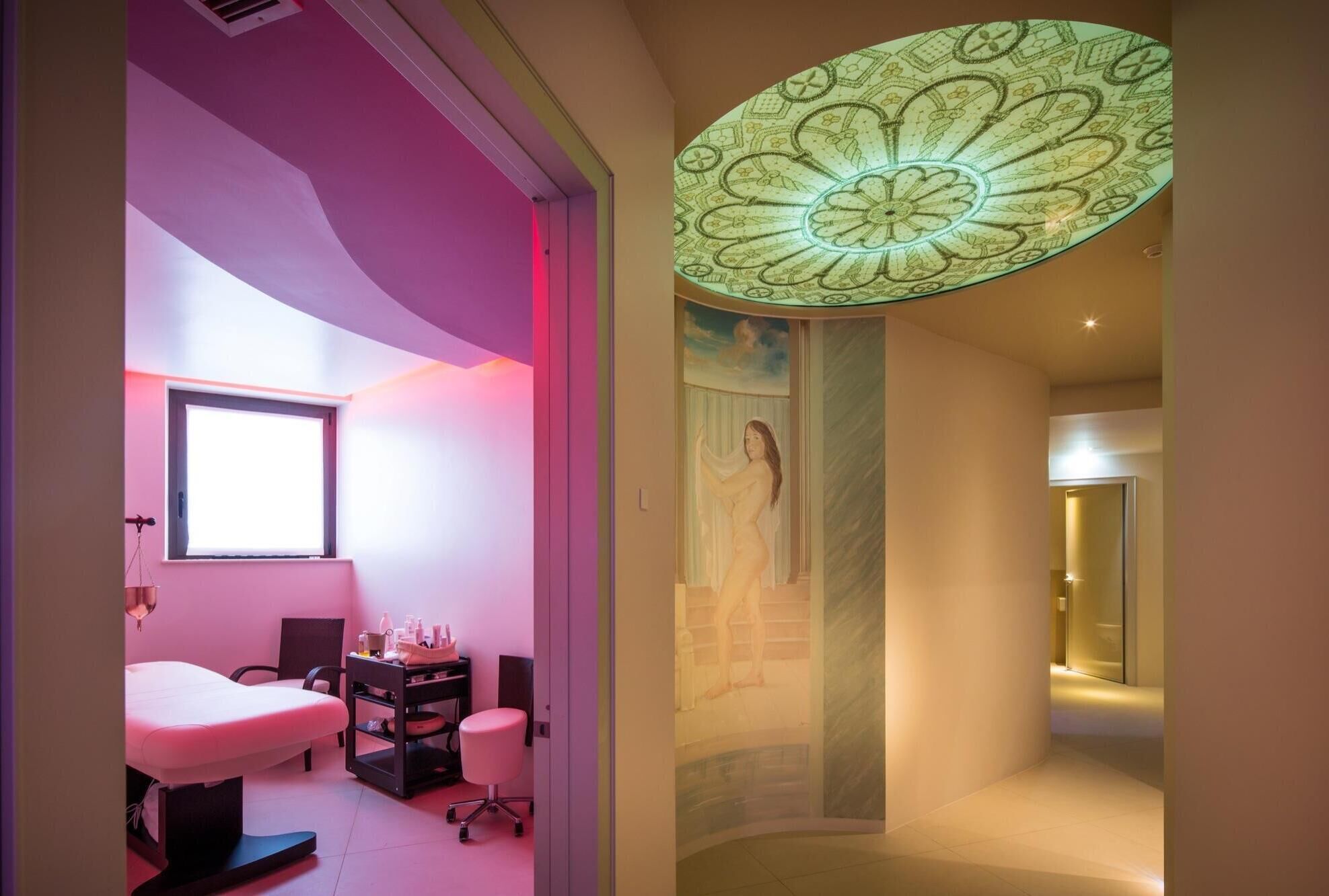 Un baño moderno con un espejo grande, un tocador y una lámpara de techo original.