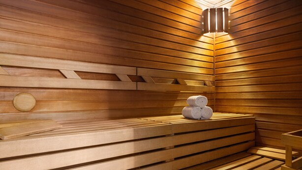 Una sauna con bancos de madera y una pila de toallas.