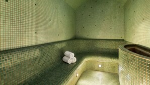 Un cuarto de spa con piso y paredes de azulejos, un banco curvo y una pequeña piscina.